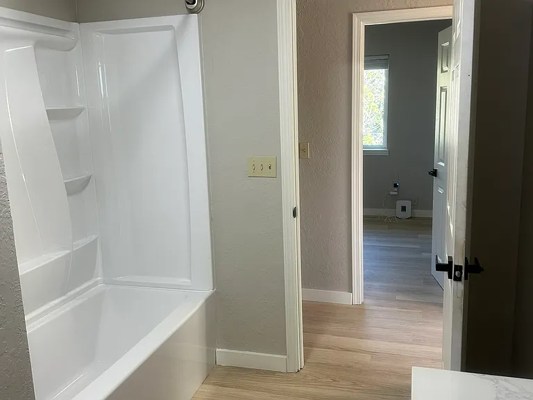 Extra roomy second Bathroom Features Bathtub with lots of shelves, modern double vanity sink