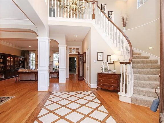 STUNNING CLASSIC ENTRYWAY - This photo gives you picturesque view of the entry with wood floors and a custom inlay of marble.