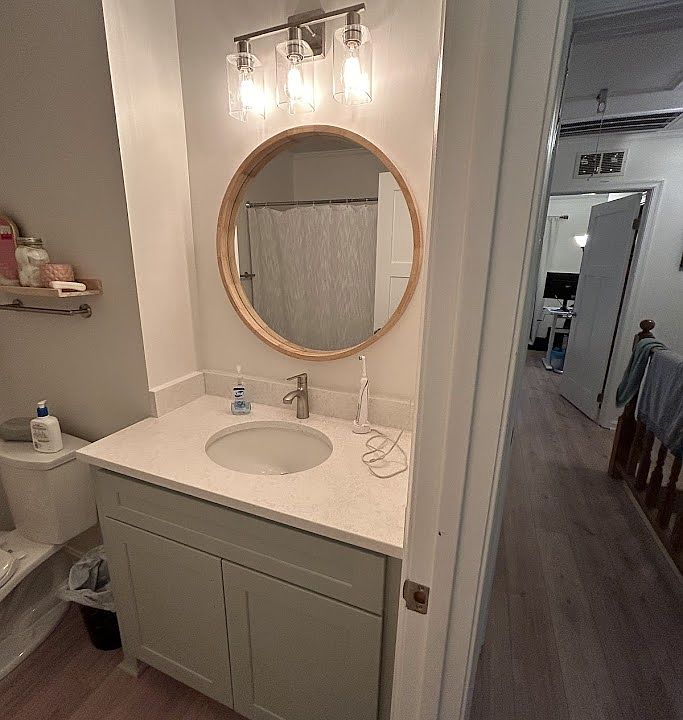 Front on suite bathroom with view down the hall to second bedroom.