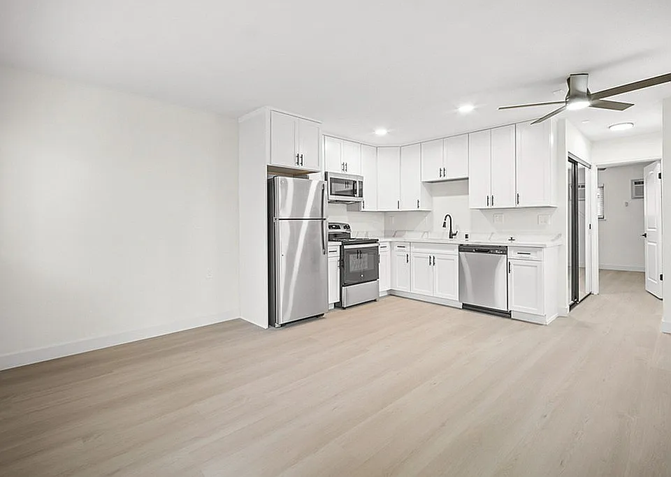 A modern open-concept kitchen flowing into the living and dining area,