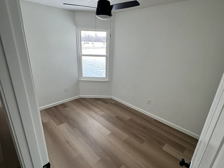 Comfortable second bedroom with bright window and LVP flooring.