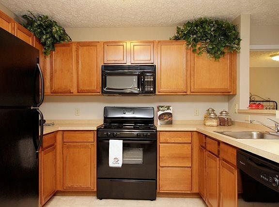 Open airy kitchen with all black appliances. Plenty of maple cabinets, over the range microwave, breakfast bar area and lots of counter space.