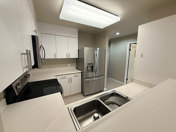 U-shaped kitchen with stainless steel applicances.