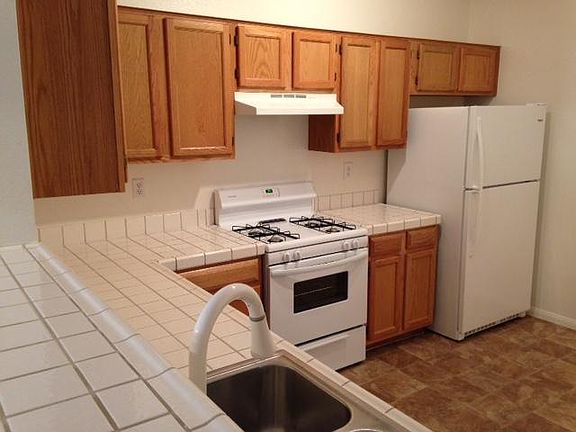 Freshly painted kitchen with pot shelves, breakfast bar, lots of storage, pantry, dishwasher, new stove, new refrigerator, and new flooring.