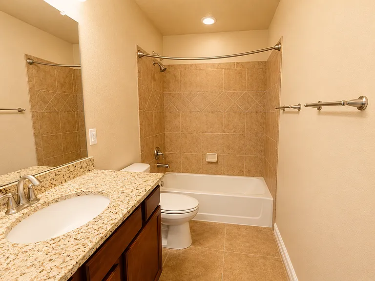 Full bathroom with granite vanity and tiled tub/shower _ shared by the two secondary bedrooms.