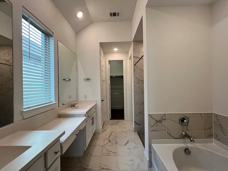 Primary bath with large walk in closet, separate shower and soaking tub.