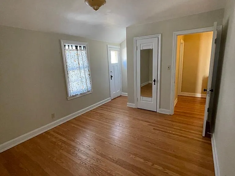 Second floor back bedroom w/ closet and door to balcony overlooking back yard.