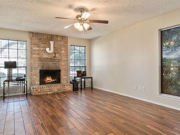 Living room with wood look tile and a charming wood burning fireplace