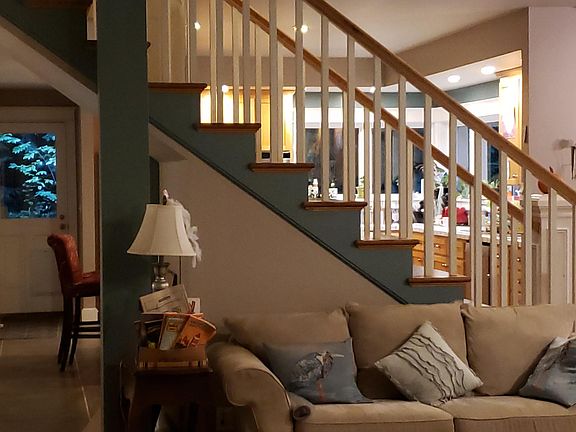 staircase with kichen on the other side, island with stools in kitchen (for 6). Dining room/couches can be moved to alternate areas according to your taste.