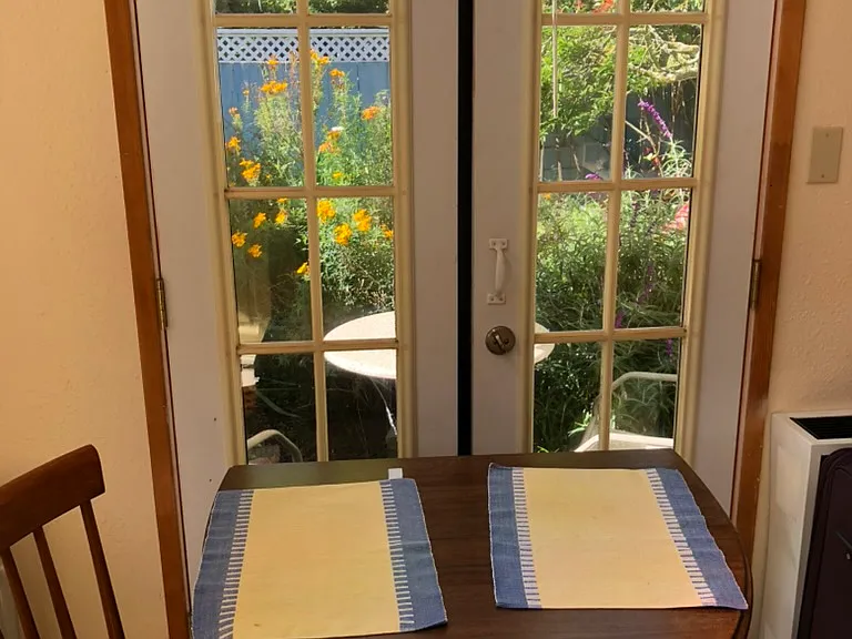 French doors with view of garden; fold out table and chairs