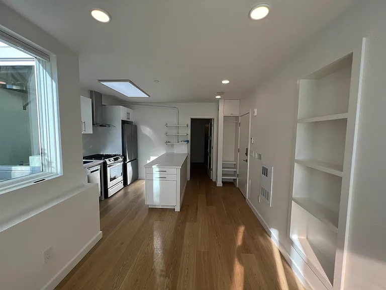 Living area facing kitchen and bedroom in the back