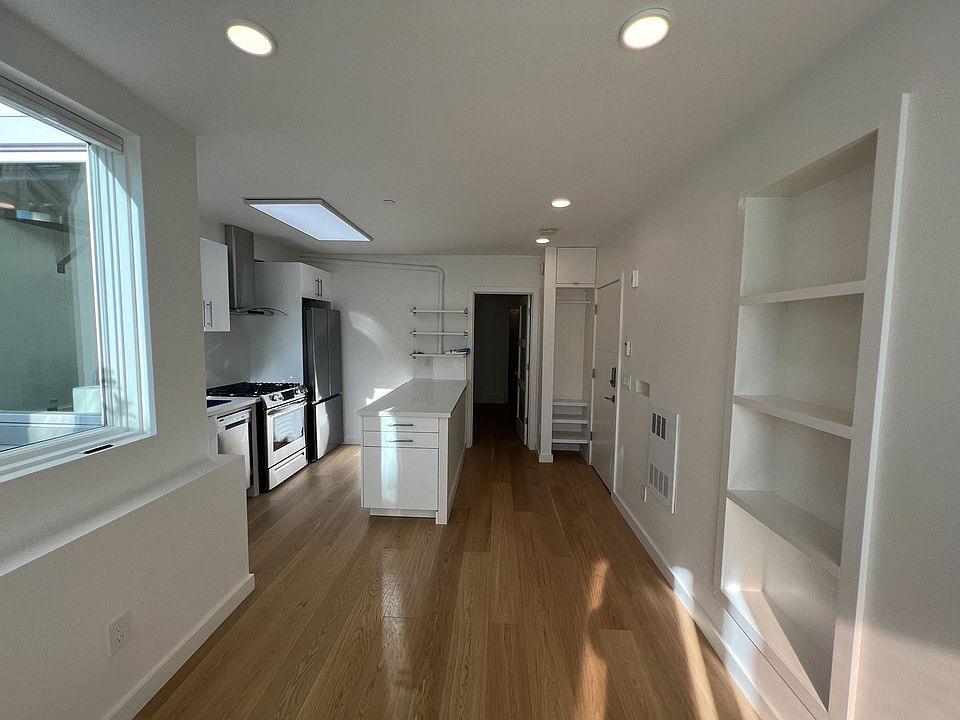 Living area facing kitchen and bedroom in the back