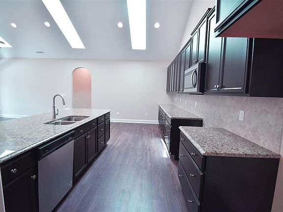 Open kitchen to family room with Espresso cabinets, granite countertops and ceramic tile backsplash