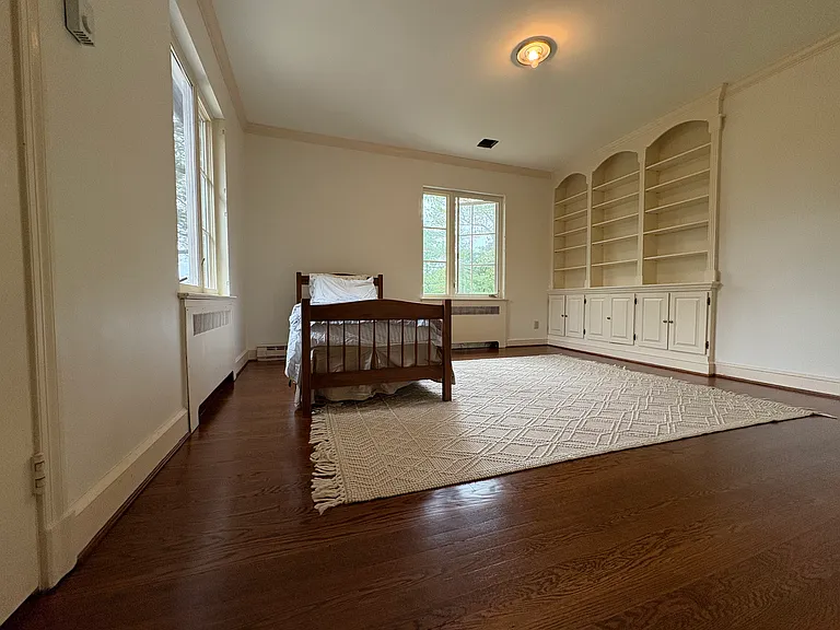Very sunny bedroom with built-in, solid wood shelving. The second bedroom of the jack-n-jill bathroom. Floors redone in 2025. Walls and ceilings reskimmed and painted in 2025