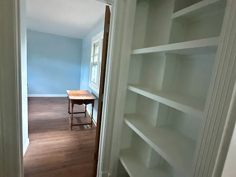 Linen closet shelving opposite main bath, leading to south bedroom