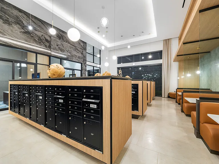 Modern and elegant apartment lobby featuring sleek mailboxes, stylish lighting, and cozy seating areas for a welcoming ambiance.