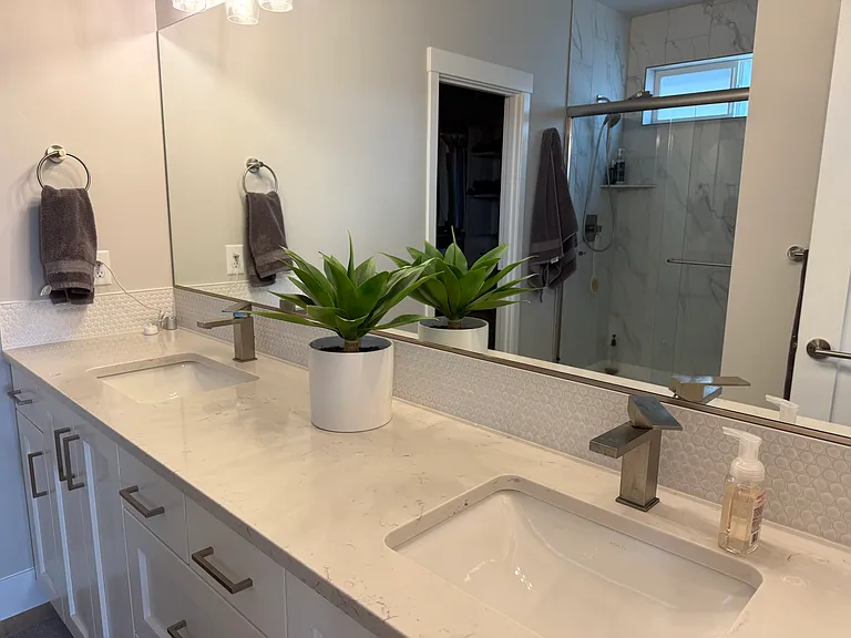 Master bathroom with dual sinks, shower and walk in closet