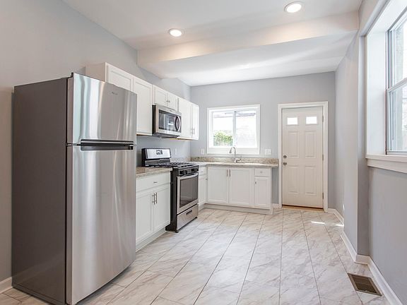 All new sunny kitchen: Stainless steel fridge, stove, & microwave, granite countertops, new sink with gooseneck faucet; new cabinetry & hardware; new windows