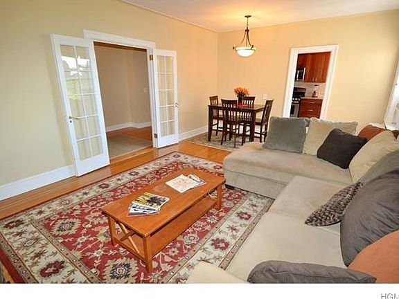 Large living room has in-layed hardwood floors and French doors leading to the large entry foyer.  The room is 21'-0" x 13'-0".