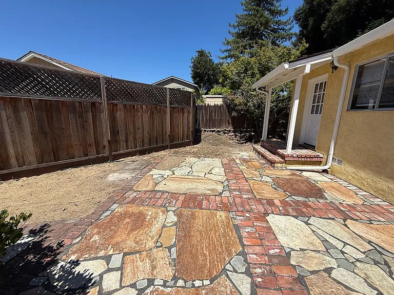 Private relaxing backyard with brick and stone pavers.