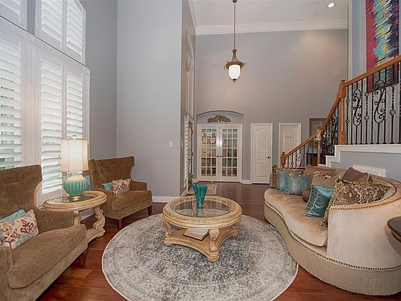 One of the many bonuses in the home is the formal living room AND a study, which is entered through the paned French doors. Note the high ceilings and windows with Plantation shutters.