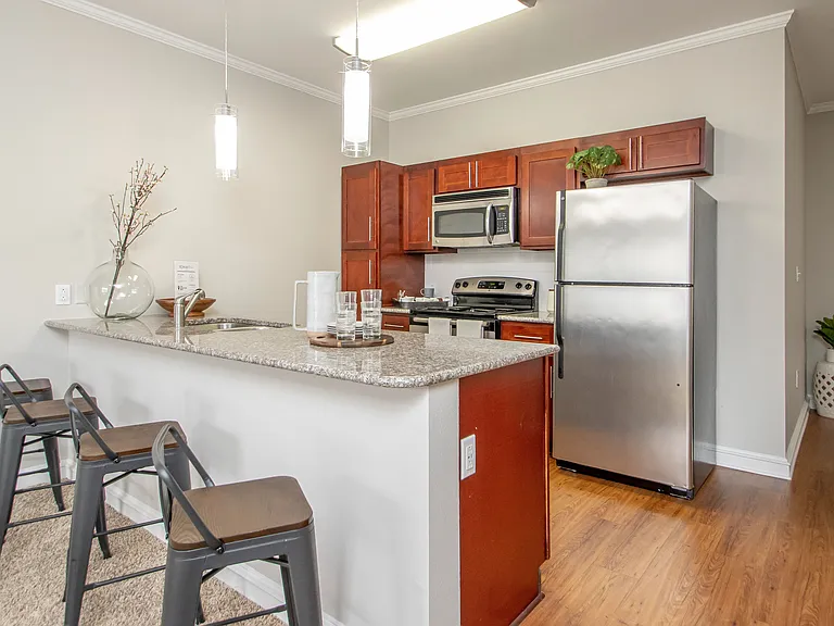 Feel joyous as you discover the elegance of our marvelous chef-inspired kitchens, adorned with captivating cherry wood cabinets and gourmet granite countertops, creating a charming space for whipping up culinary masterpieces.