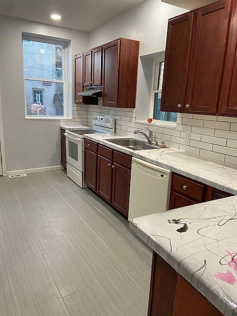 spacious kitchen with an extra large kitchen sink and exhaust fan