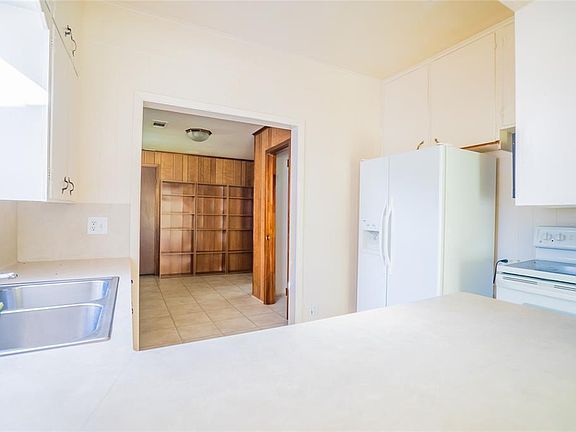 Another view of kitchen looking back towards back door. Small closet on right, 3rd bedroom next to it. Nice bookshelves for readers or college students. Door just to left of bookshelves is another big walk-in closet.