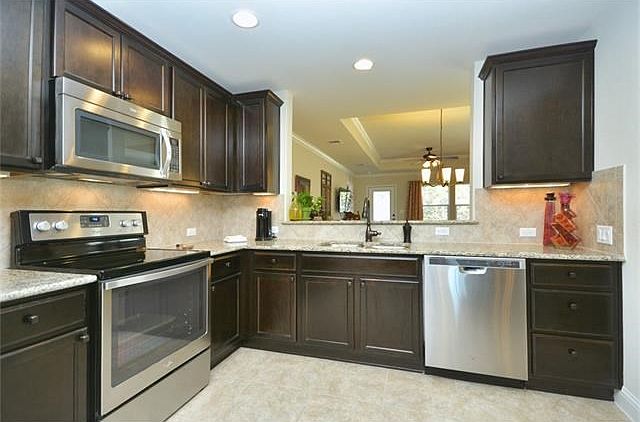 Gleaming stainless steel appliances and gorgeous granite counter tops circle the magical Open Kitche