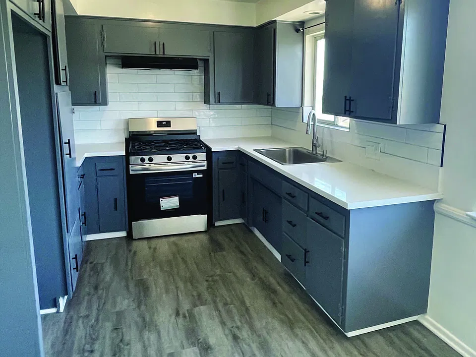 Remodeled kitchen with new quartz, tile, paint, stove, and sink. Large Stainless Sink with new Hardwood floor laminate.