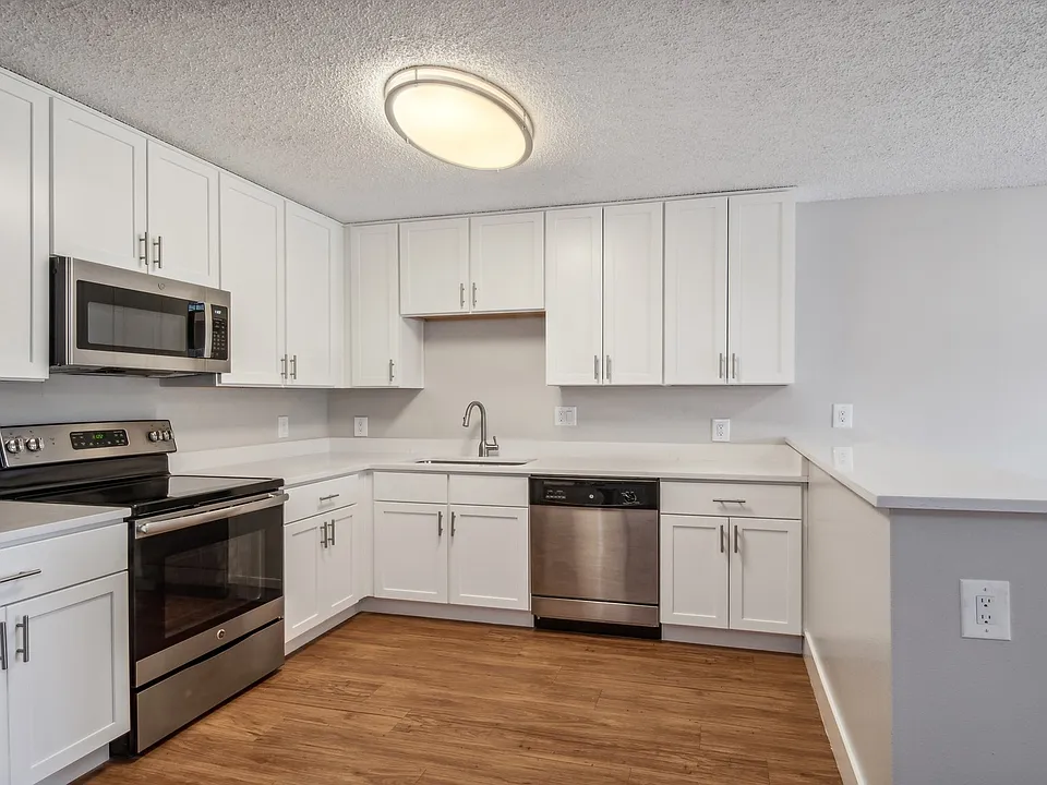 Kitchens offer stainless steel appliances and wood flooring