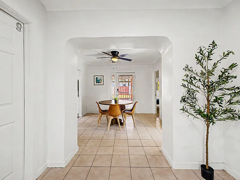 Dedicated dining area with tiled floors, ceiling fan, and direct access to the backyard through a glass door.