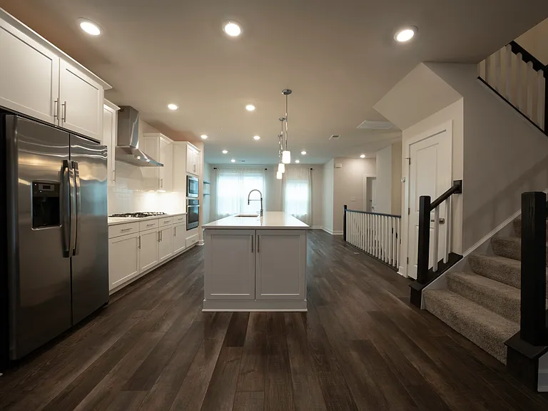 Kitchen features stainless steel appliances, gas range, large island, quartz countertops, under-cabinet lighting and outlets, lots of cabinetry and overhead lighting. Lights are smart/WiFi-enabled.