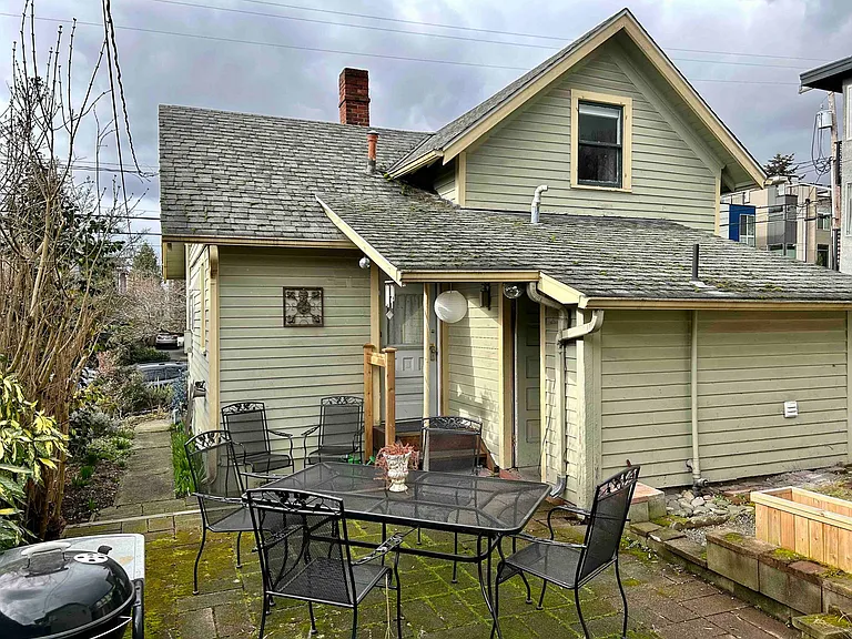 private backyard with mature gardens including blue berries, raspberries, persimmon and 4-season flowering plants