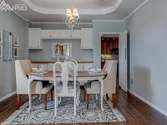 Dining room with bamboo flooring, built-ins and Tray Ceiling