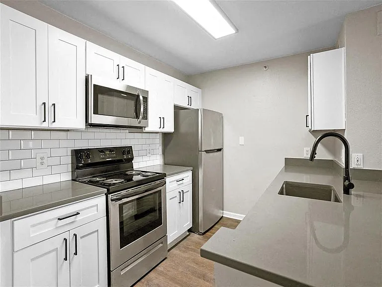Renovated kitchen with granite countertops, subway tiled backsplash & stainless steel appliances at The Crossings at Russett in Laurel, MD