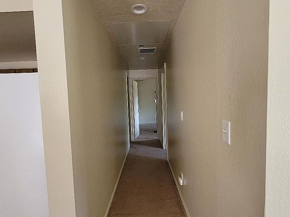 Hallway leading to two bedrooms and bathroom.