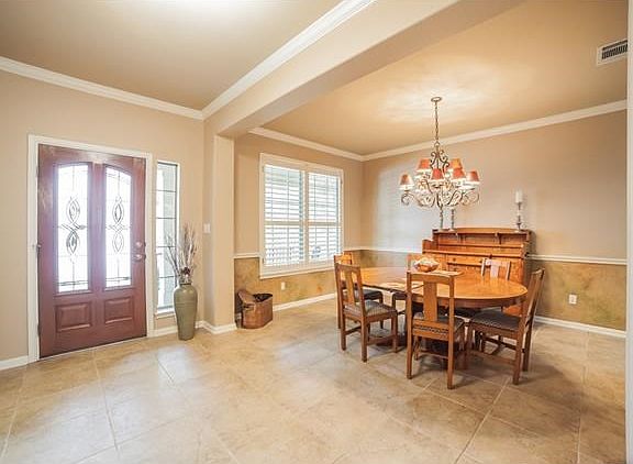 Charming entry and fabulous dining area with custom moldings and plantation shutters!