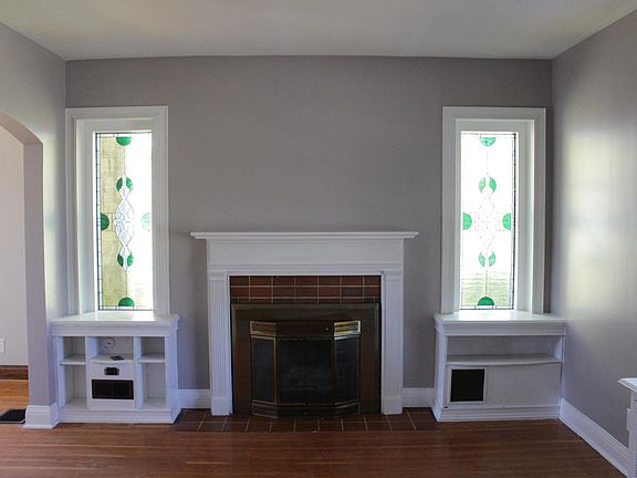 Living room with one-of-a-kind stained-glass windows and hardwood floors.