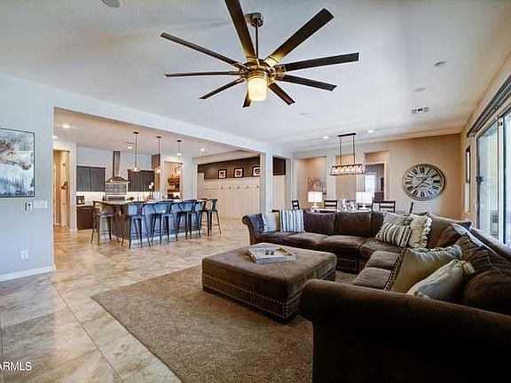 large ceiling fan and oversized granite island with seating for 6