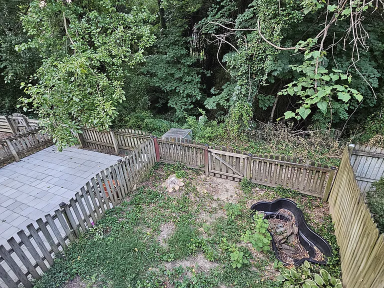 View from below the deck into the backyard- black koi pond was previously filled and fully functional. Get creative with your new space!