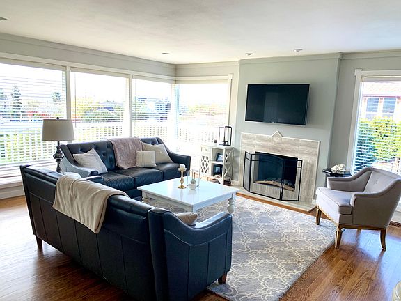Living room with big picture windows facing south. Gas fireplace.