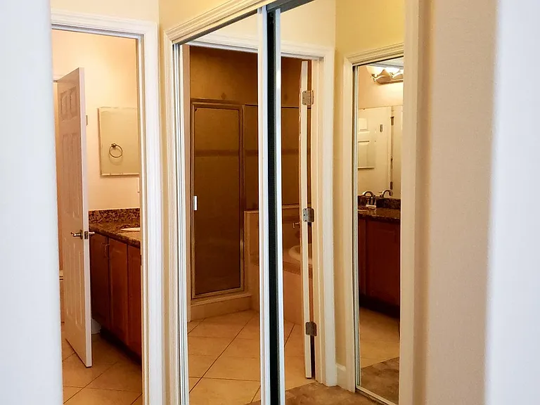 Master bedroom corridor to the bathroom has closet with mirror doors