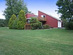Backyard view of home on huge level lot completely lined with treea
