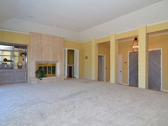 Large family room with wet bar overlooks back patios and pool