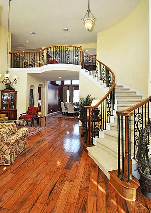 Hardwood floor entry with beautiful iron stairwell, soaring ceilings, lots of natural light.