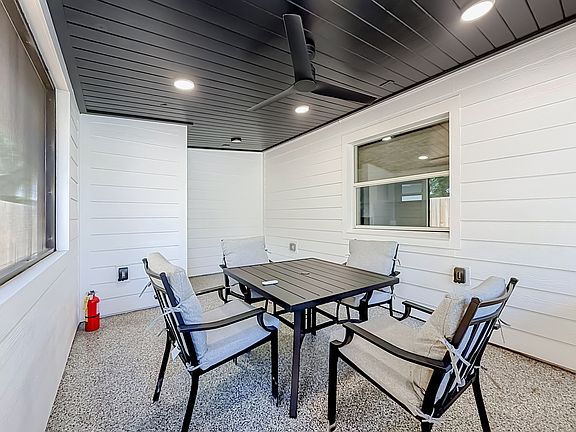 Spacious screened in patio with epoxy floor, wood ceiling fan and a table with four chairs to unwind after a hard day of work, park fun or visiting family.