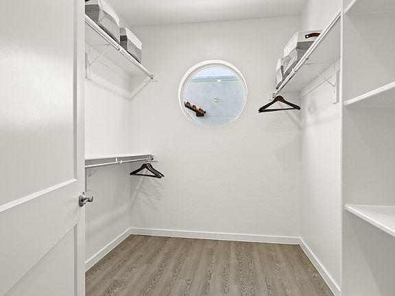 Large walk-in closets with wooden floors