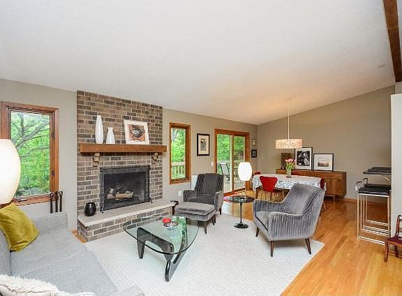 Open living concept with vaulted living room, wood burning fireplace and adjacent dining.