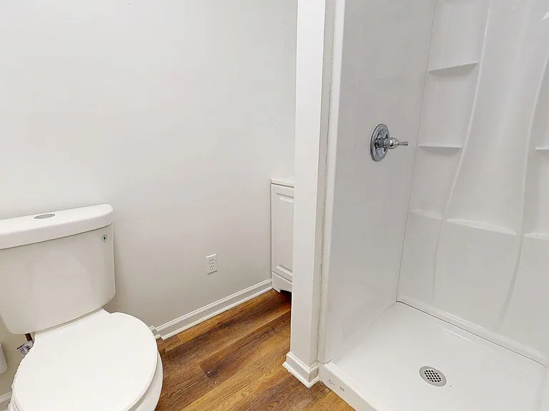 Clean bathroom with a walk-in shower featuring built-in shelving and easy-care finishes for everyday convenience.